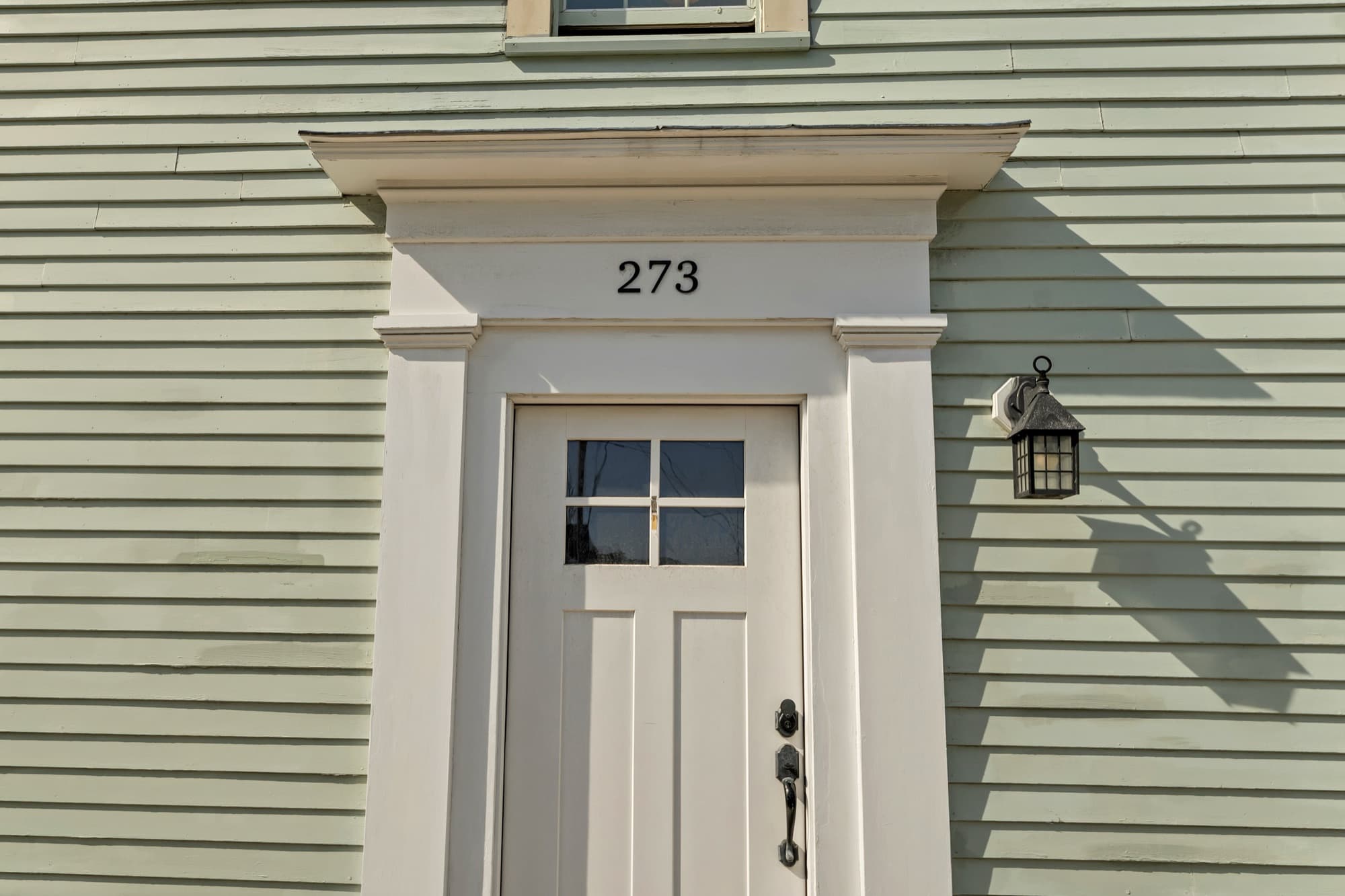 Front entry with the number 273 above a paneled door