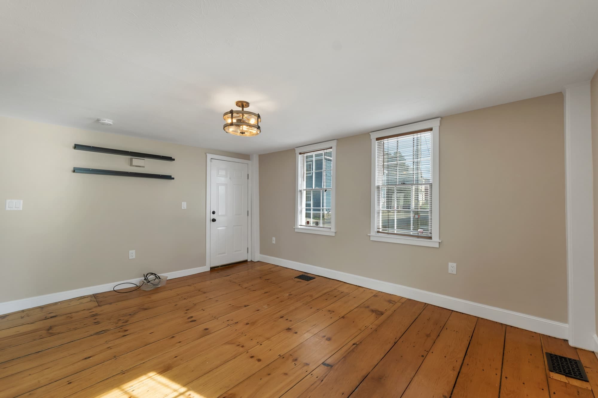 Living room with wide-plank hardwood floors and a built-in shelf