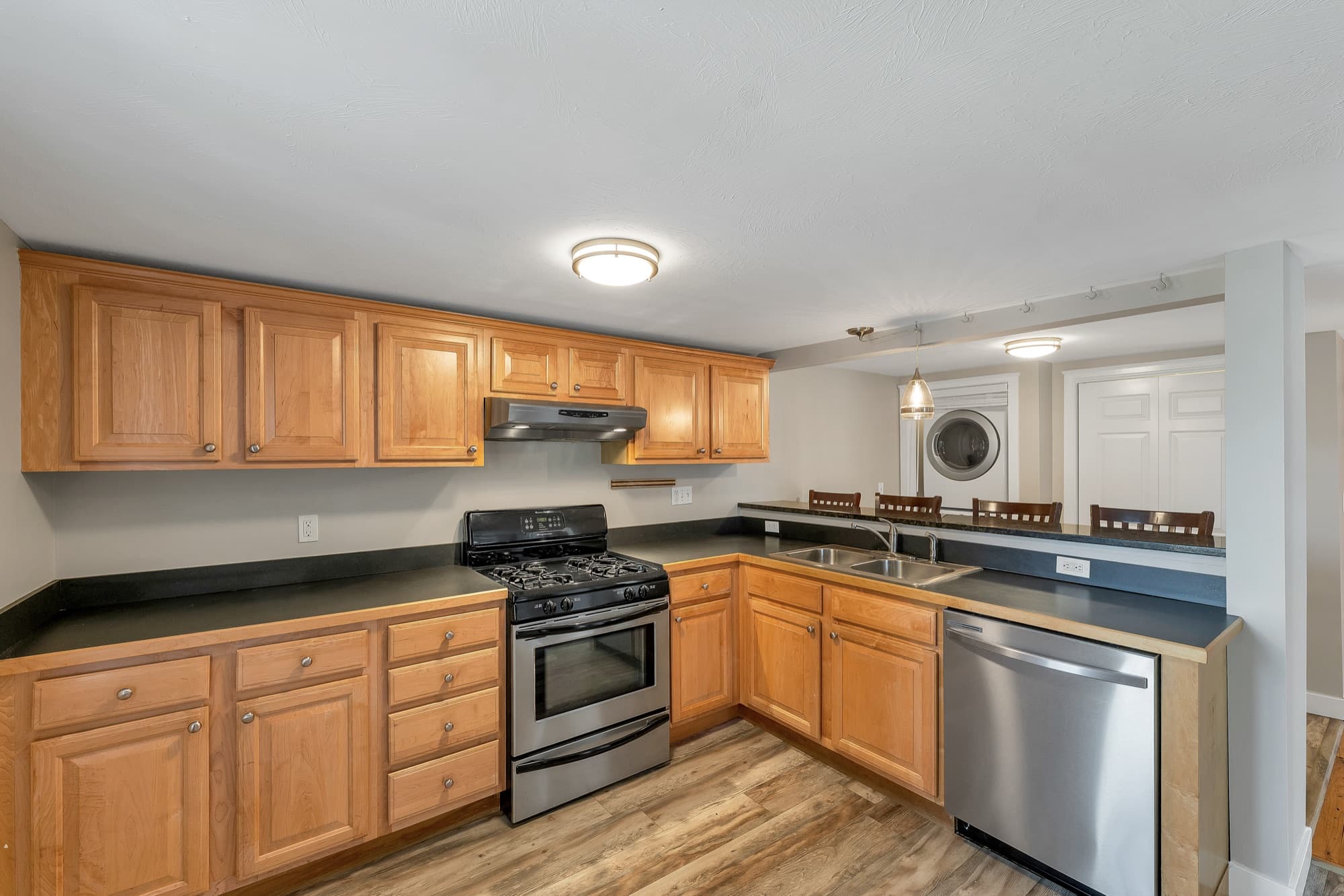 Updated kitchen with wood cabinetry, a gas range, and a stainless dishwasher