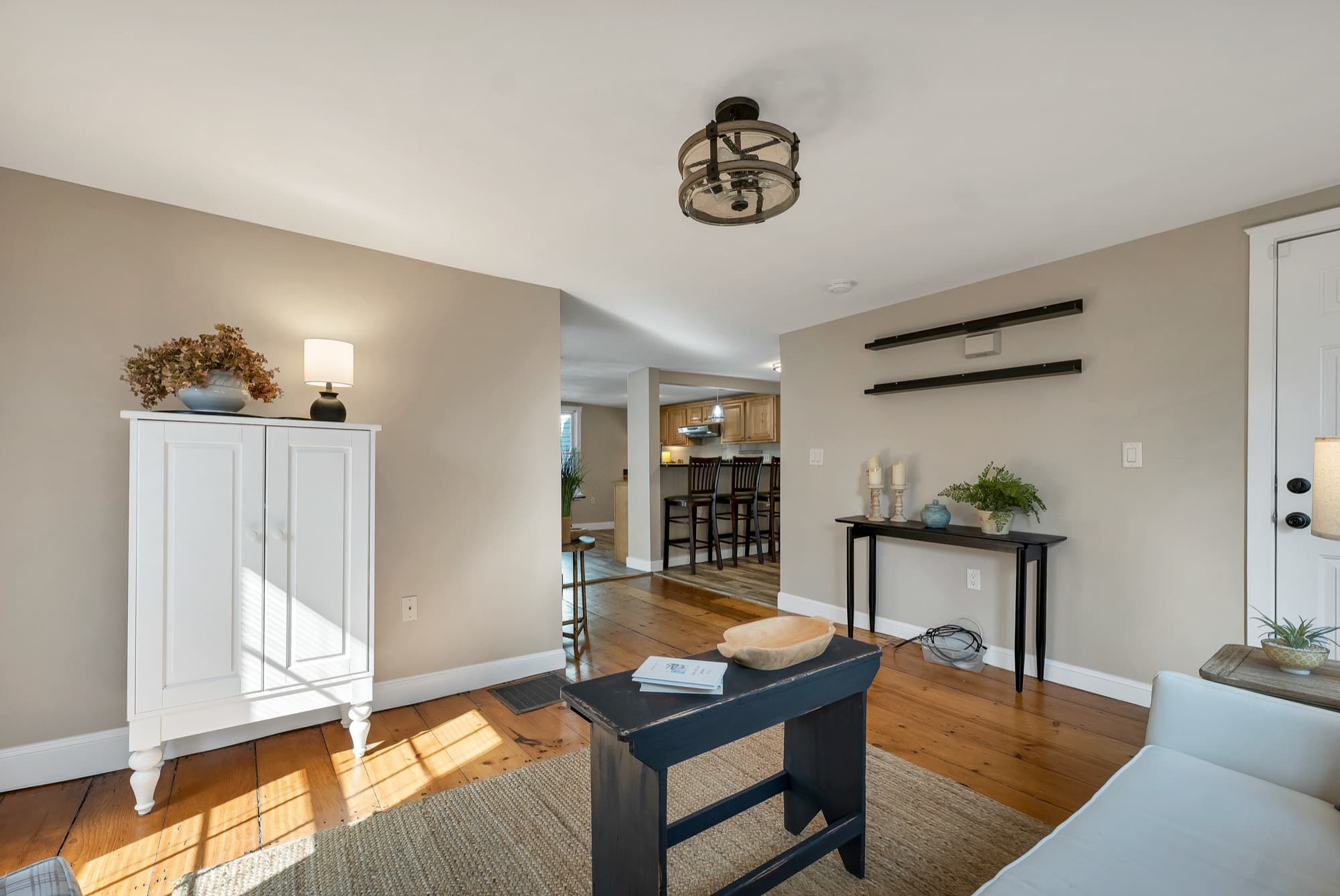 Staged living area opening to the kitchen and bar seating