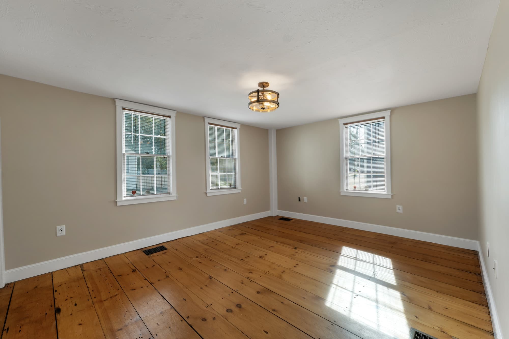 Sun-filled living and dining area with hardwood floors
