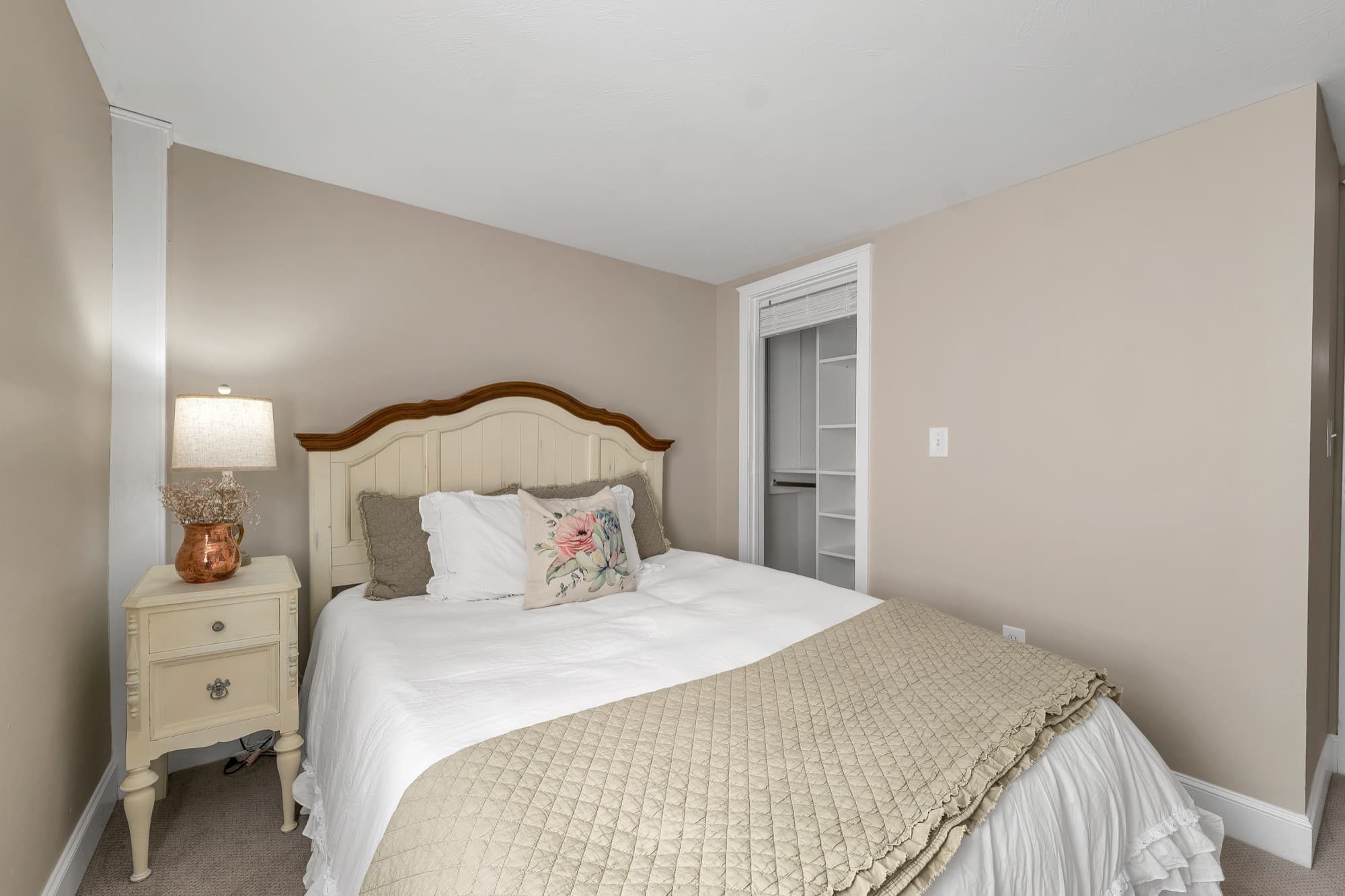 Staged bedroom with a closet and soft neutral tones