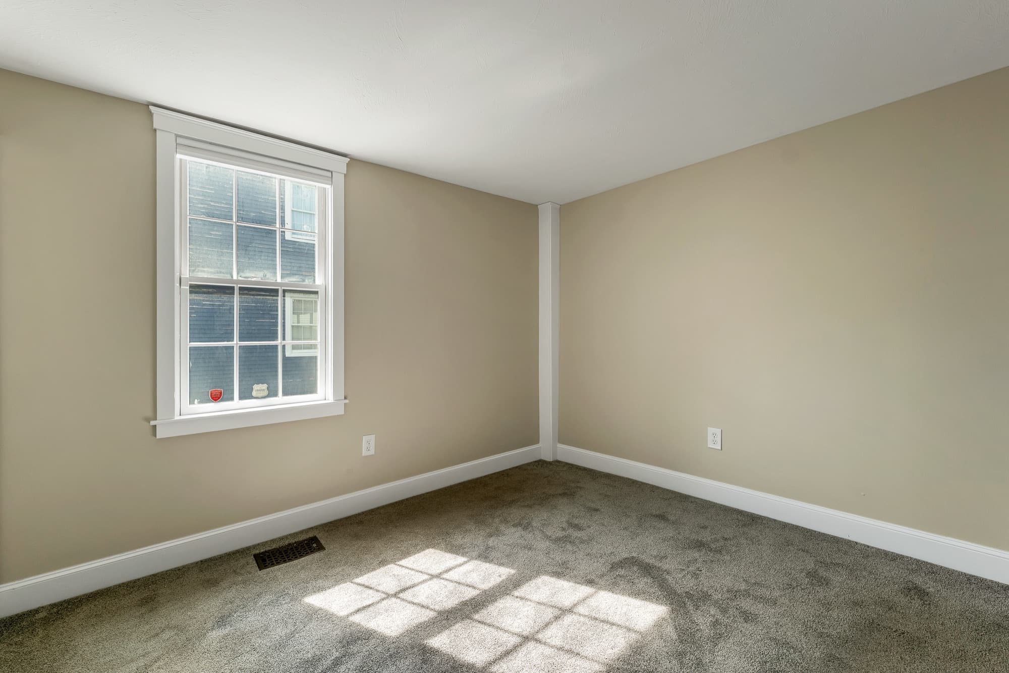 Carpeted bedroom with a bright window